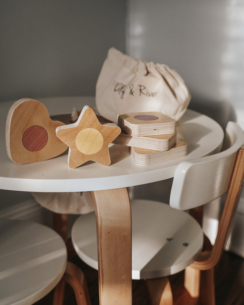 Montessori wooden heart, star, and stack of square toys on a table